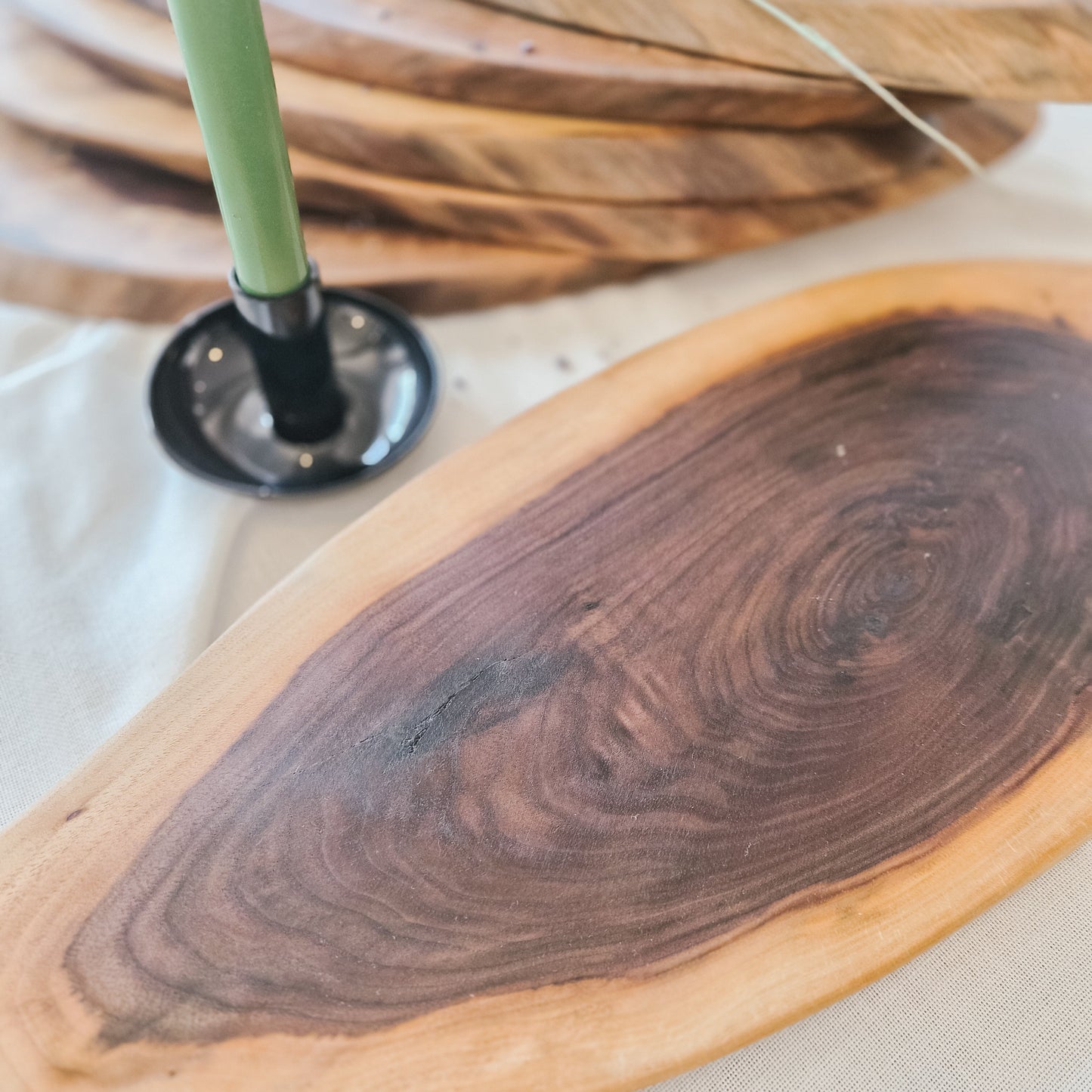 Wooden cutting board with a green-handled knife on a white surface