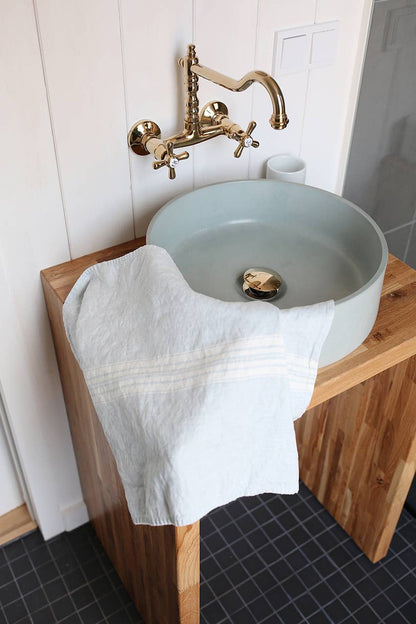 Bathroom sink with wooden countertop and gold faucet
