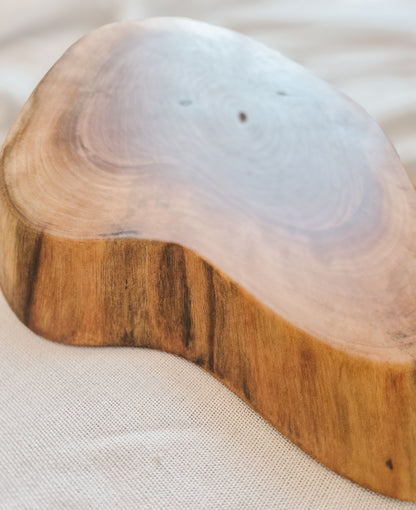 Wooden coaster with a clear resin top on a light fabric background