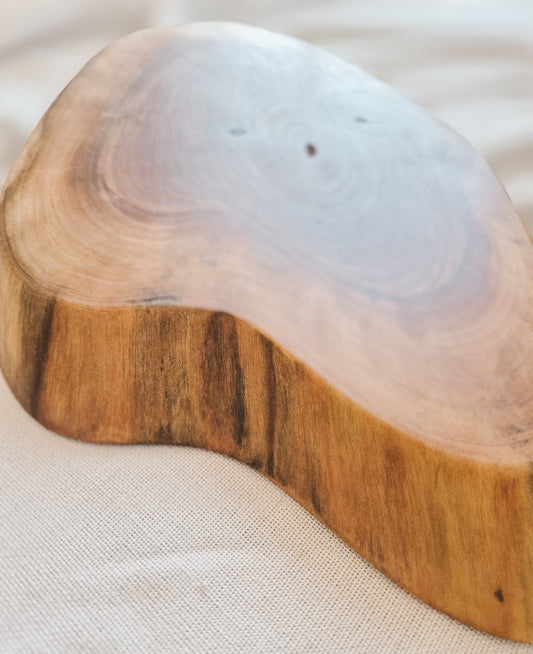 Wooden coaster with a clear resin top on a light fabric background