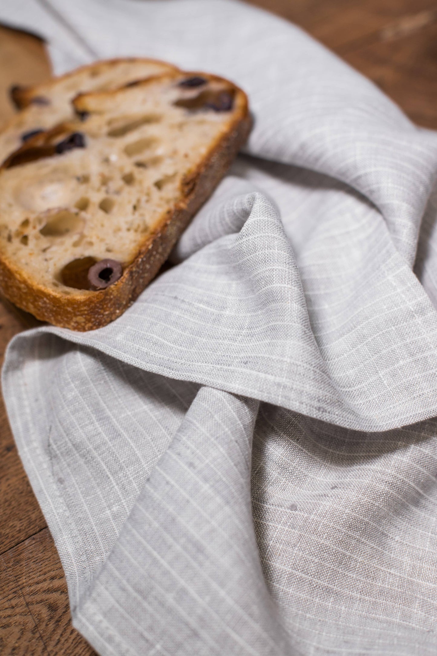 Sliced bread on a textured gray cloth with a wooden surface underneath