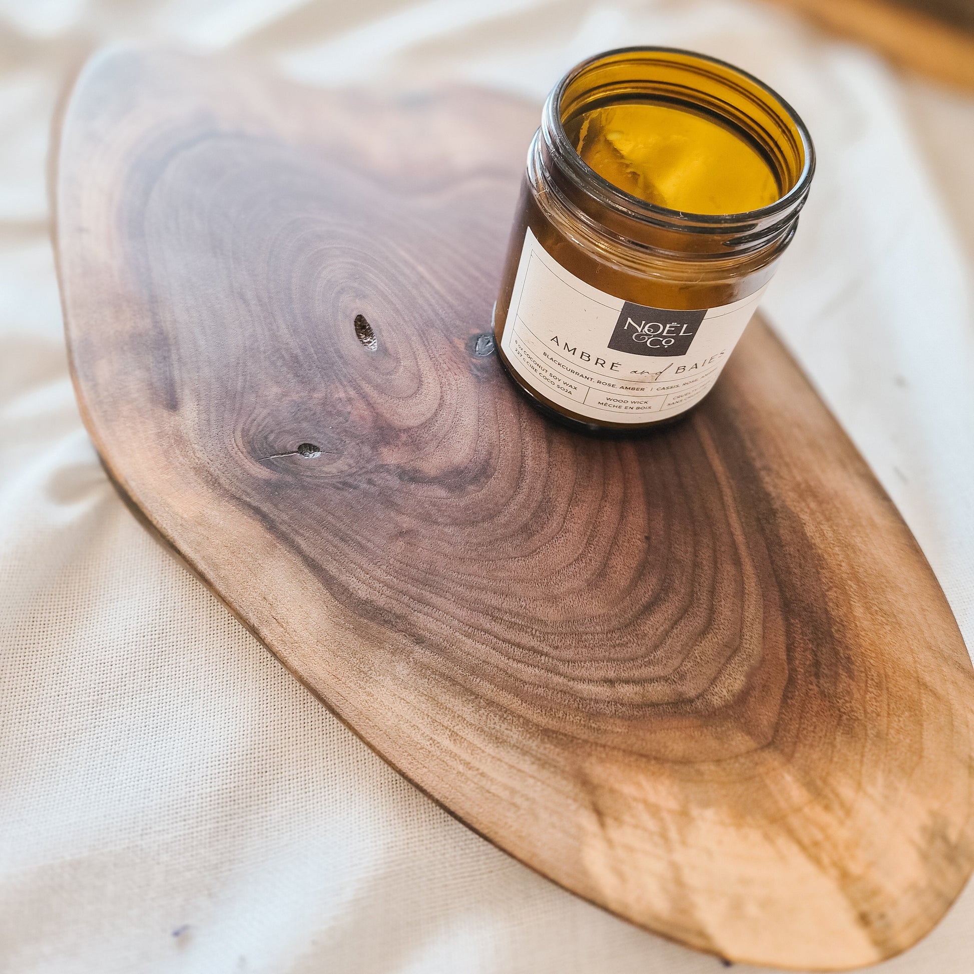 Jar of candle on a wooden board with a soft background