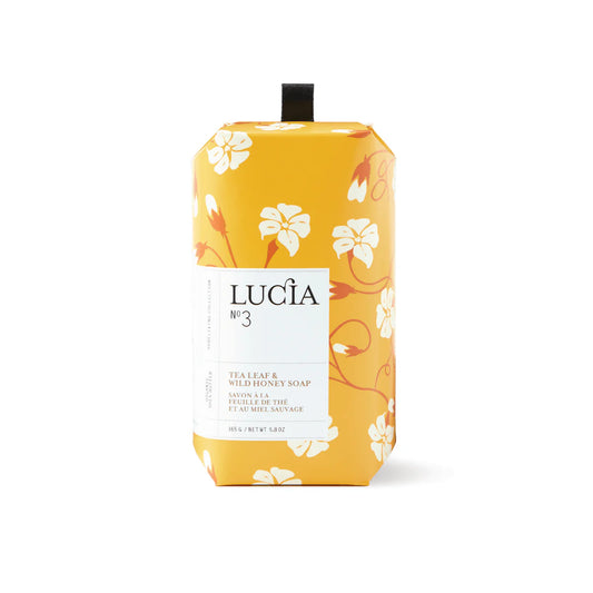 Yellow soap packaging with floral design and 'Lucia' branding on a white background