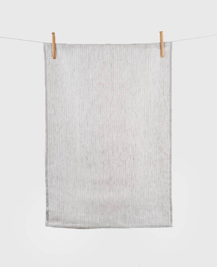 Gray towel hanging on a clothesline with wooden clips against a white background