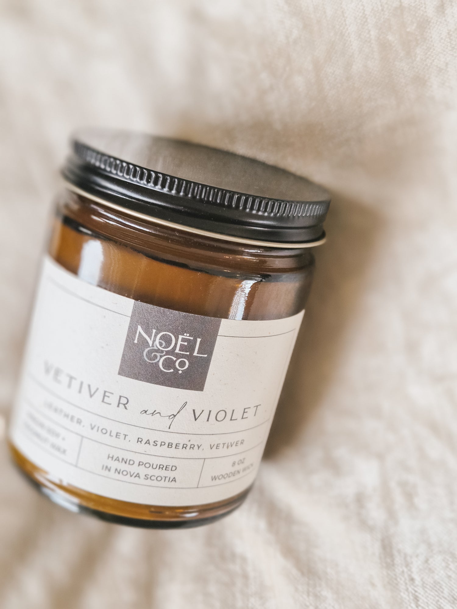 Candle jar labeled 'Noel & Co' on a soft white background