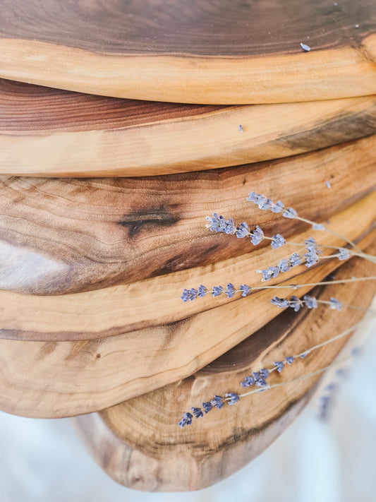 Stack of wooden cutting boards with lavender on a white background