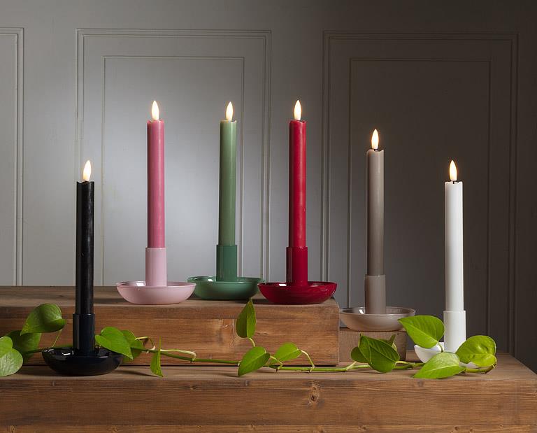 Set of colorful candles on a wooden surface with a neutral background